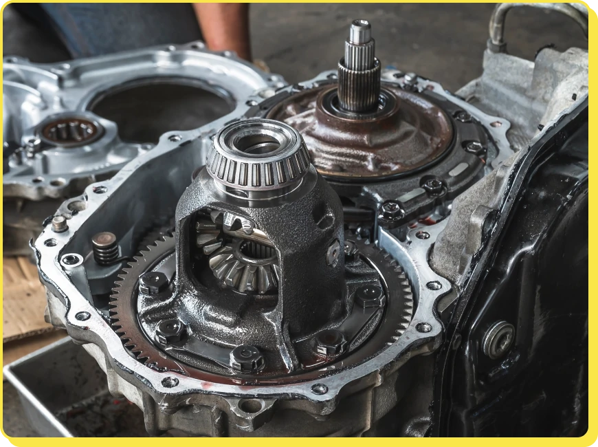 At Jerry's Automotive. Close-up of an exposed automotive gearbox showing gears and mechanical components. The photo focuses on the intricate details of the transmission system, including the visible gears and metal casing parts.