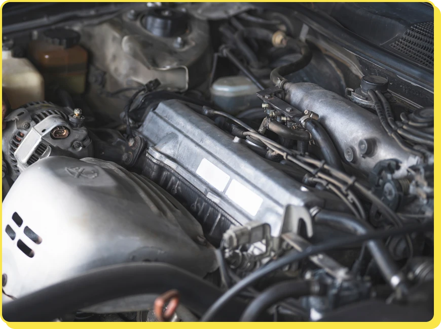 At Jerry's Automotive. Close-up of a car engine, showing various components including belts, hoses, and metal parts within the engine compartment.