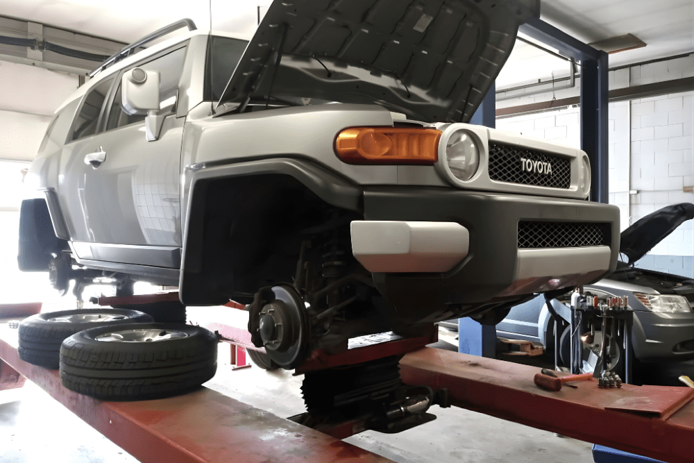 Auto repair near Holt, MI by Jerry’s Automotive. Image of a Toyota SUV lifted on a shop hoist with wheels removed, showcasing professional brake service to ensure vehicle safety and reliable performance.