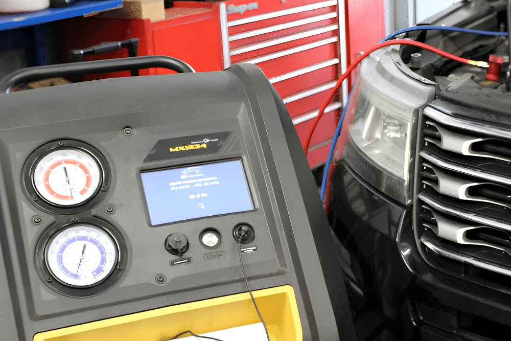 Auto Air Conditioning Service in Lansing MI at Jerry's Automotive. Close-up view of an auto A/C recharge machine with red and blue gauges during car air conditioning service