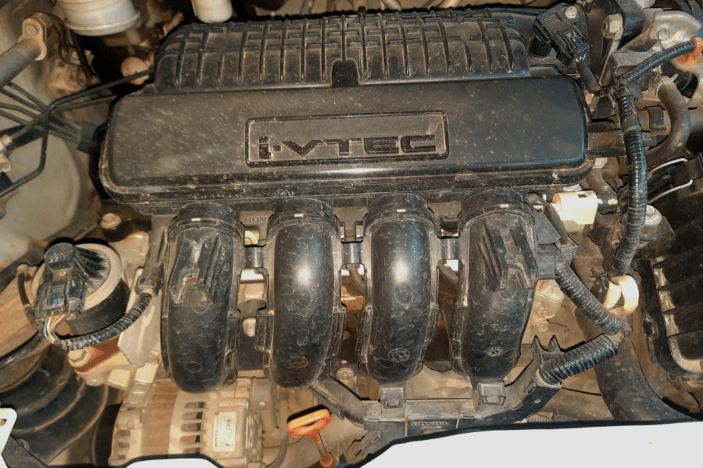 Domestic V8s vs. Import 4-Cylinders, Engine Repair in Lansing MI At Jerry's Automotive. Image of Honda i-VTEC 4-cylinder engine inside a car engine bay