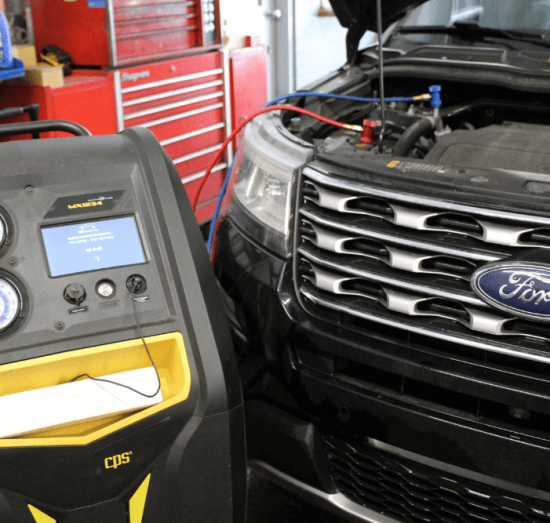 Auto A/C Repair in Lansing, MI by Jerry's Automotive. Image shows a Ford vehicle undergoing air conditioning service with a CPS A/C machine connected under the hood.